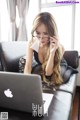 A woman sitting on a couch using a laptop computer.