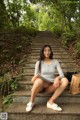 A woman sitting on the steps of a set of stairs.