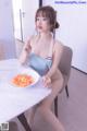 A woman sitting at a table with a plate of food.