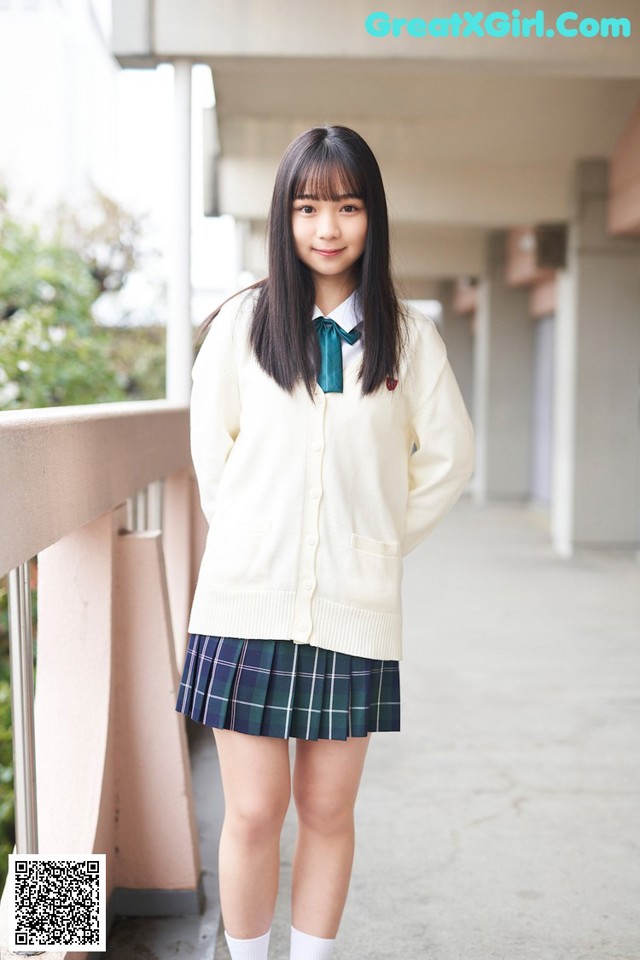 A young woman in a school uniform posing for a picture.