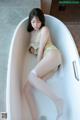 A woman sitting in a bathtub with her legs crossed.