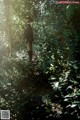 A woman standing in the middle of a forest.