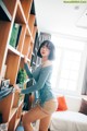 A woman standing in front of a bookshelf in a living room.